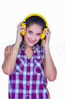 Pretty brunette listening music with headphone and looking at ca
