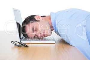 exhausted businessman sleeping head on laptop