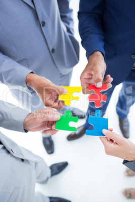 Business colleagues holding piece of puzzle