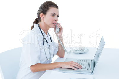 Doctor working on her laptop and calling