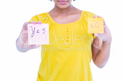 Pretty hipster holding yes and no sheets of paper