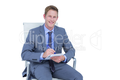 Businessman writing down on a notebook