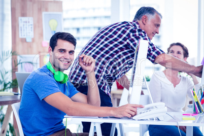 Smiling photo editors using computer in office