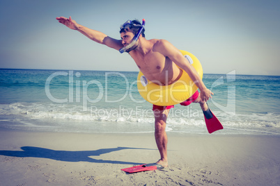 Man wearing flippers and rubber ring at the beach