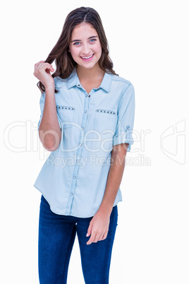 Pretty hipster smiling at camera with a hand in her hair