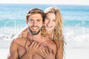 Happy couple relaxing together in the sand