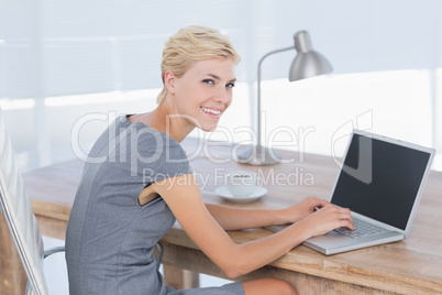 Smiling businesswoman using her computer