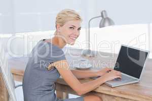 Smiling businesswoman using her computer