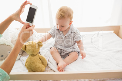 Happy mother taking a picture of her baby boy