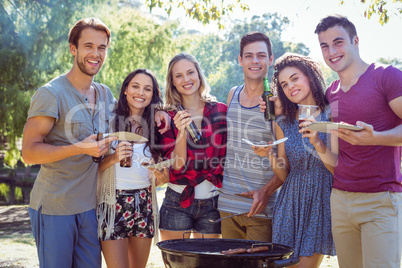 Happy friends in the park having barbecue