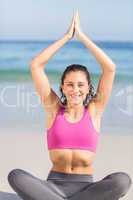 Fit woman doing yoga beside the sea