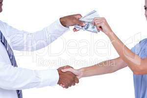 Business people shaking hands and exchanging bank notes