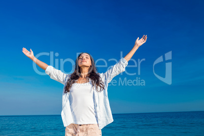 Happy woman with eyes closed at the beach