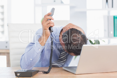 Frustrated businessman phoning at his desk