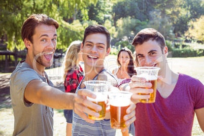 Happy friends in the park having beers