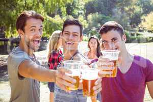 Happy friends in the park having beers