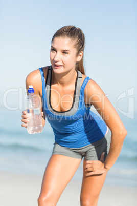 Portrait of beautiful fit woman holding bottle of water