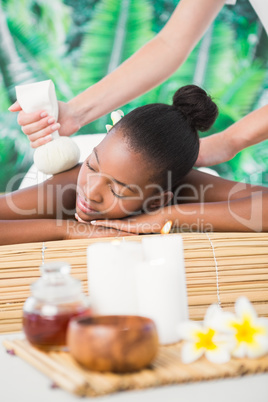 Pretty woman enjoying a herbal compress massage