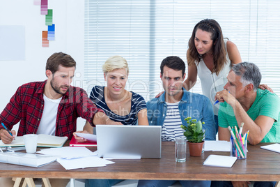 Creative business team using laptop in meeting