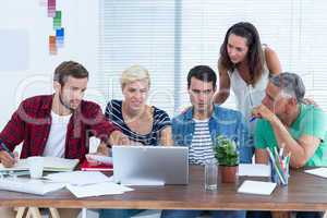 Creative business team using laptop in meeting