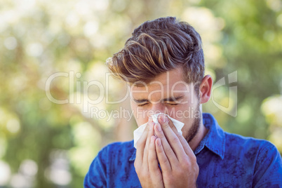 Handsome hipster blowing his nose