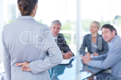 Businesswoman with fingers crossed behind her back