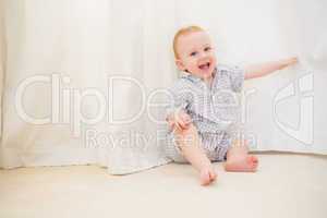 Cute baby boy sitting on floor