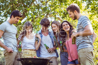 Happy friends in the park having barbecue