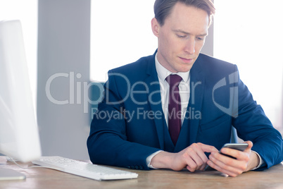 Serious businessman using his smartphone