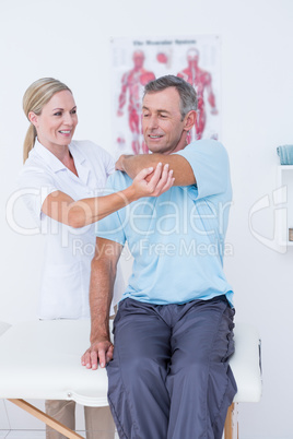 Doctor stretching a man arm