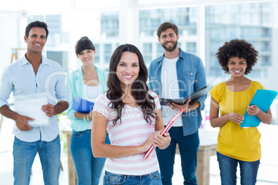 Portrait of creative business people holding files