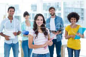 Portrait of creative business people holding files