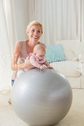 Happy mother with her baby girl in the exercice ball