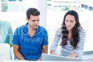 Creative business team using laptop in meeting