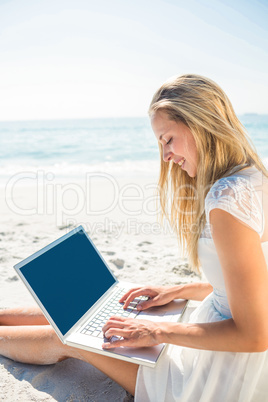 Woman using laptop and wearing hat