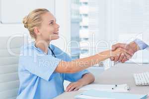 Nurse shaking hand of her colleague