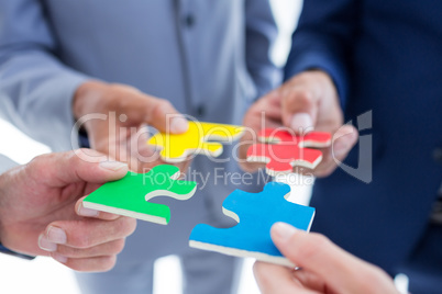 Business colleagues holding piece of puzzle