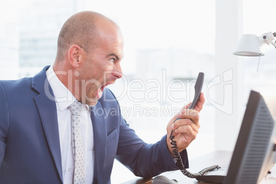 Businessman yelling at his phone