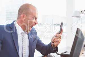 Businessman yelling at his phone