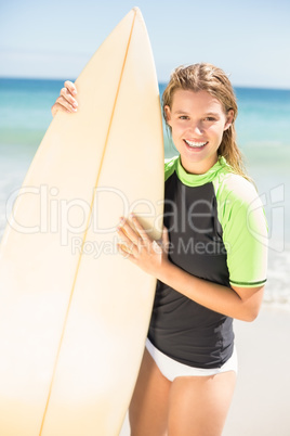 Pretty blonde woman holding surf board