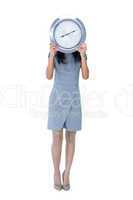 Businesswoman holding big clock in front of her face