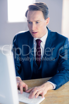 Serious businessman typing on computer