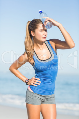 Beautiful brunette putting water bottle in her head