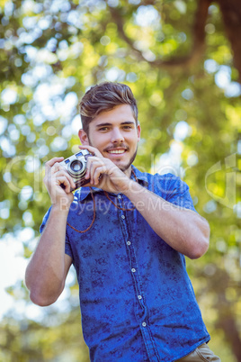 Handsome hipster holding vintage camera