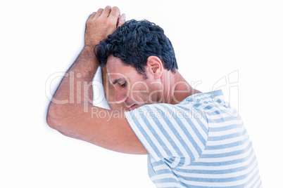 Sad man leaning his head against a wall