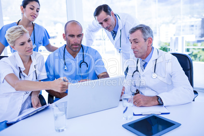 Teams of doctors working on laptop computer