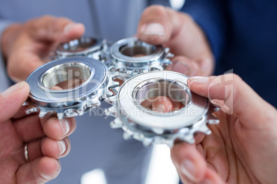 Business colleagues holding cog