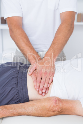 Physiotherapist doing back massage to his patient