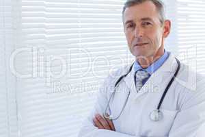 Confident male doctor looking at camera with arms crossed