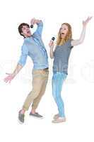 Happy couple singing into microphones